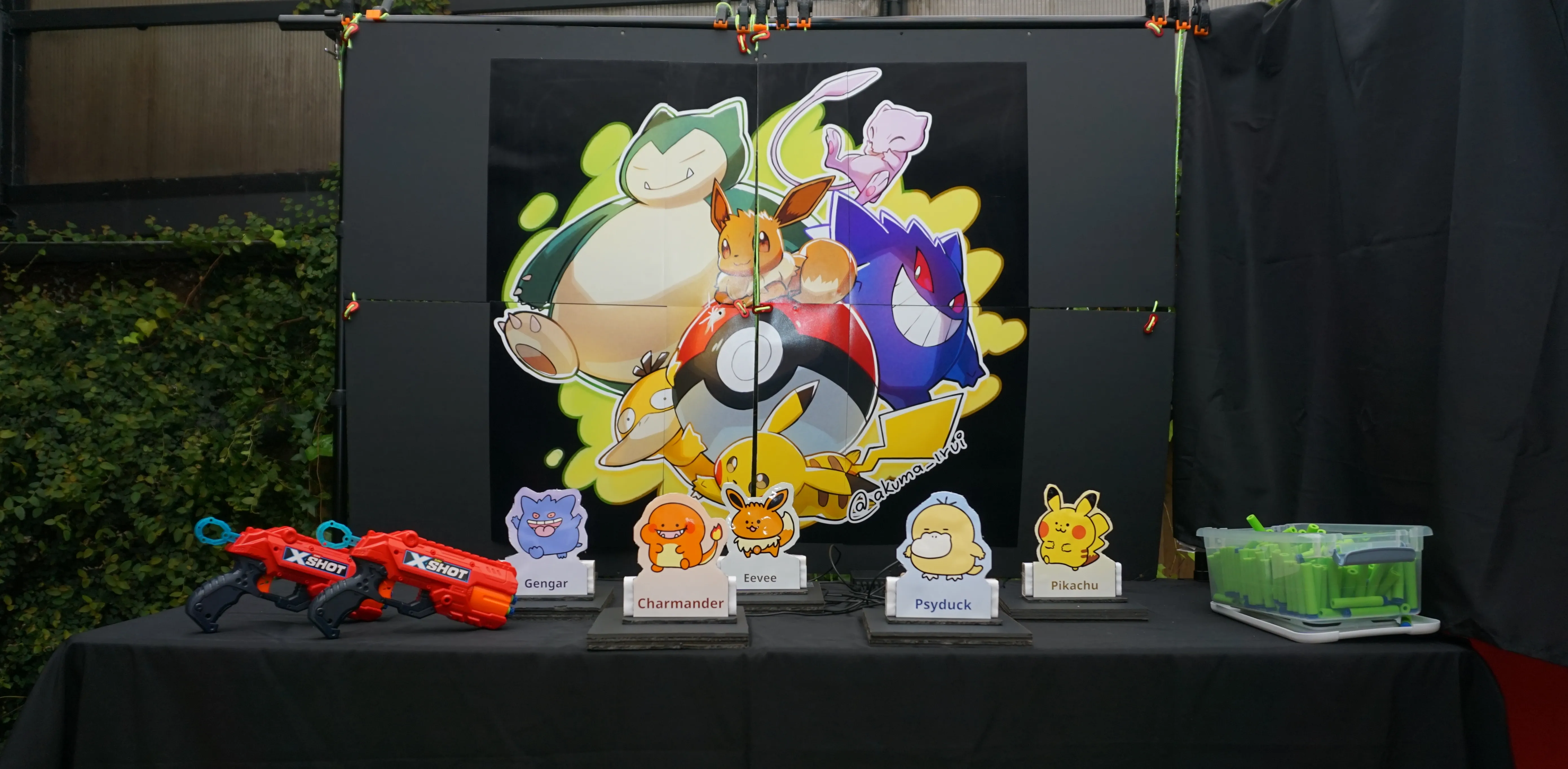 The Blaster Box booth with Pokémon target standees on the table and blasters ready to fire